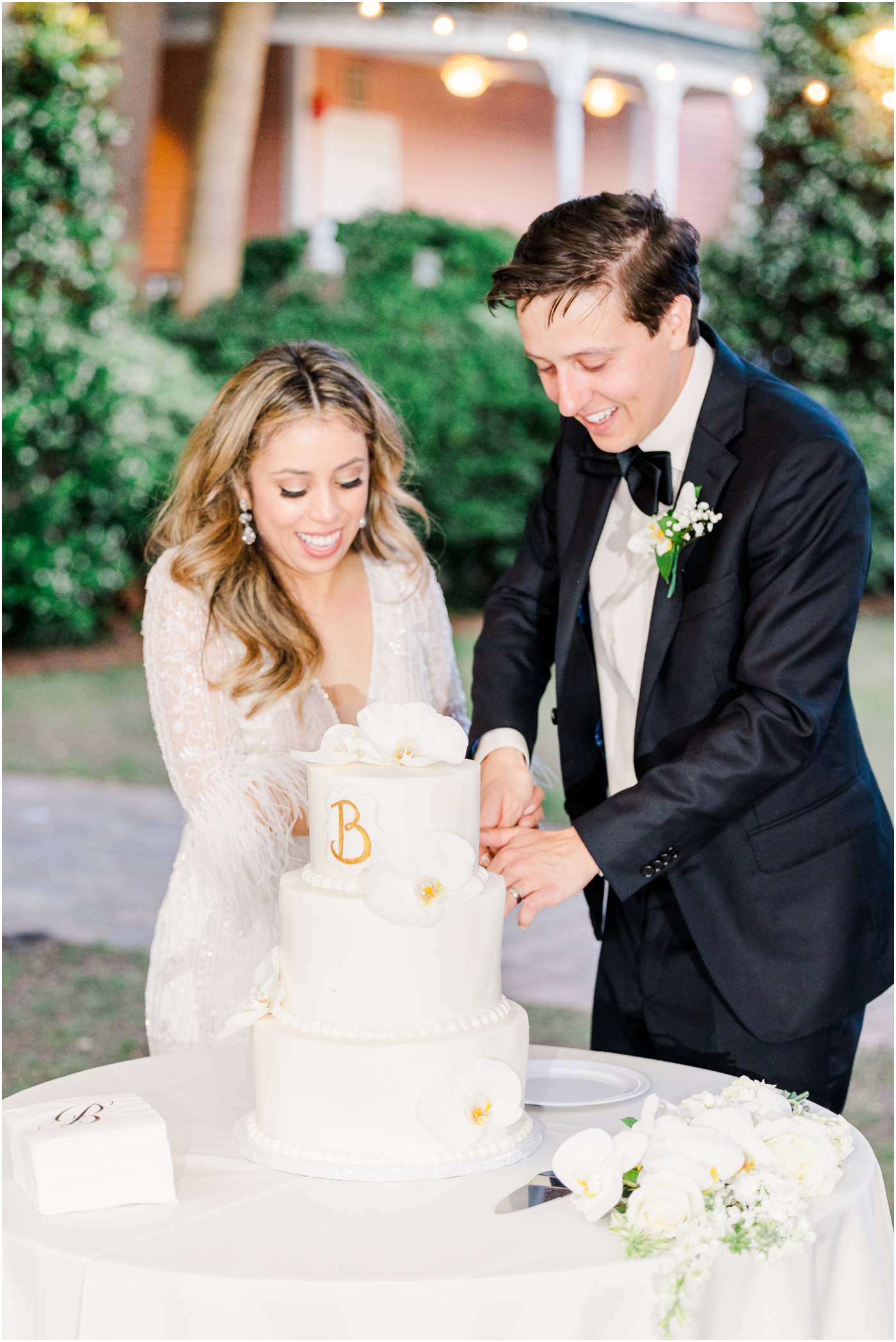 Bride & Groom cutting the cake at their Beaufort Inn wedding in the tabby garden 