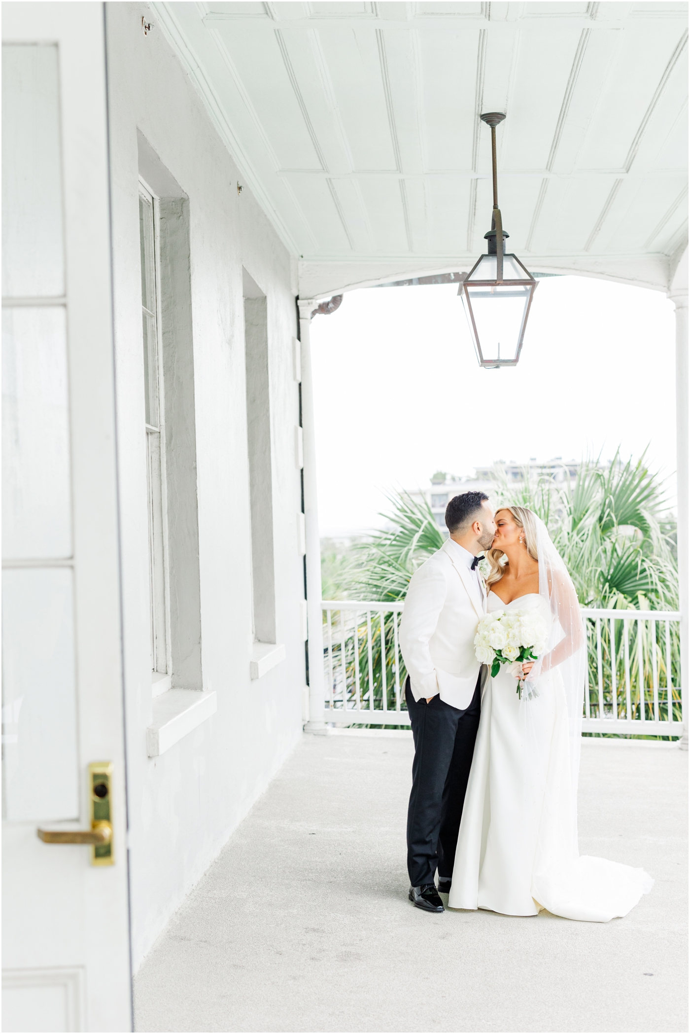Bride & Groom kissing on balcony at the Gadsden House in Charleston