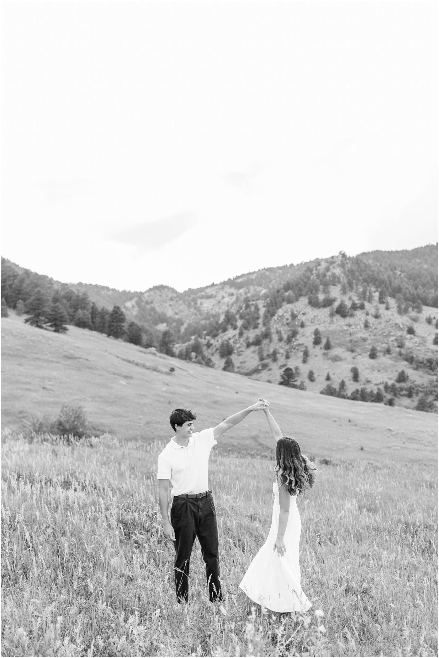 black and white photo of couple spinning in mountains