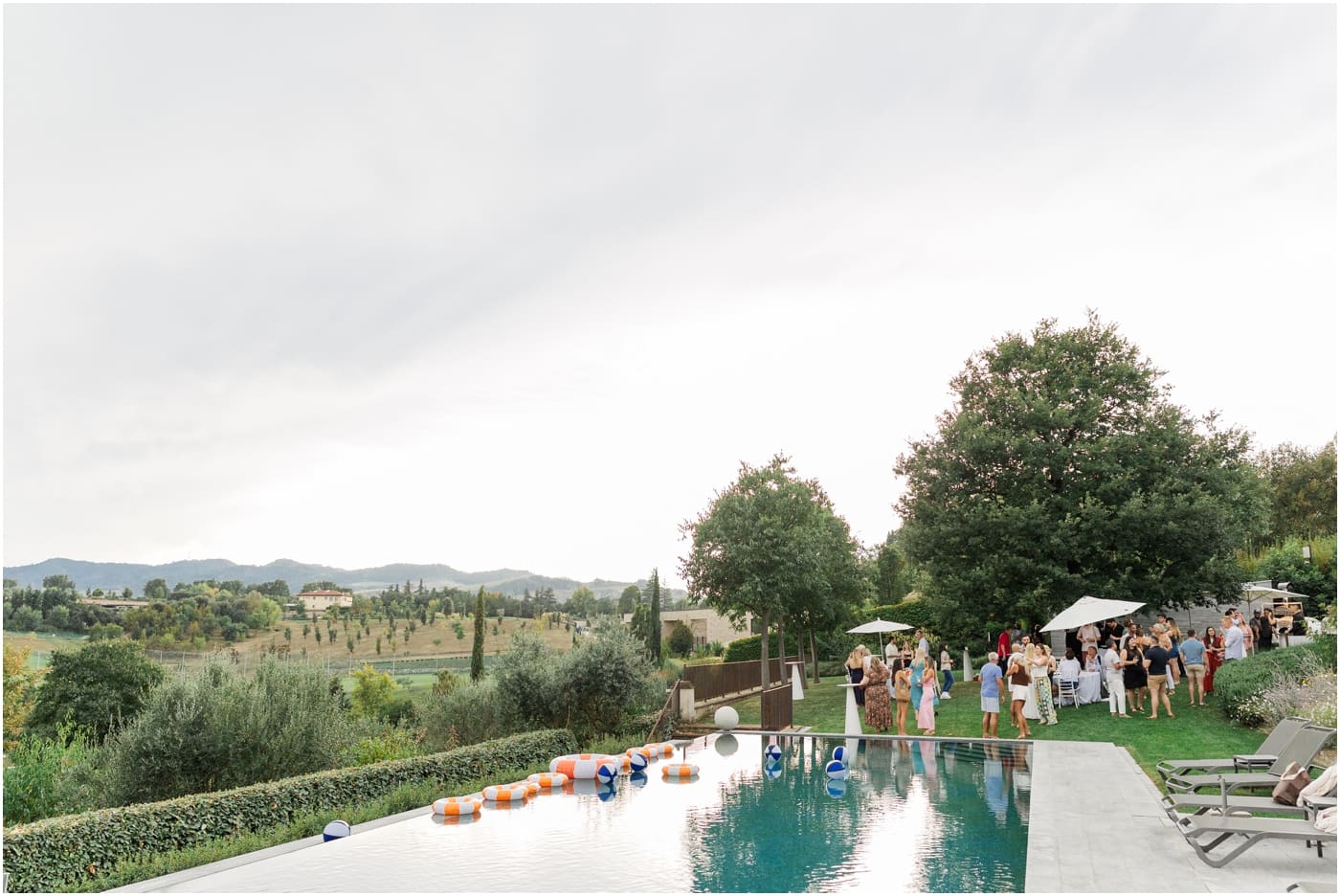 Wide scene of a poolside welcome party in Italy
