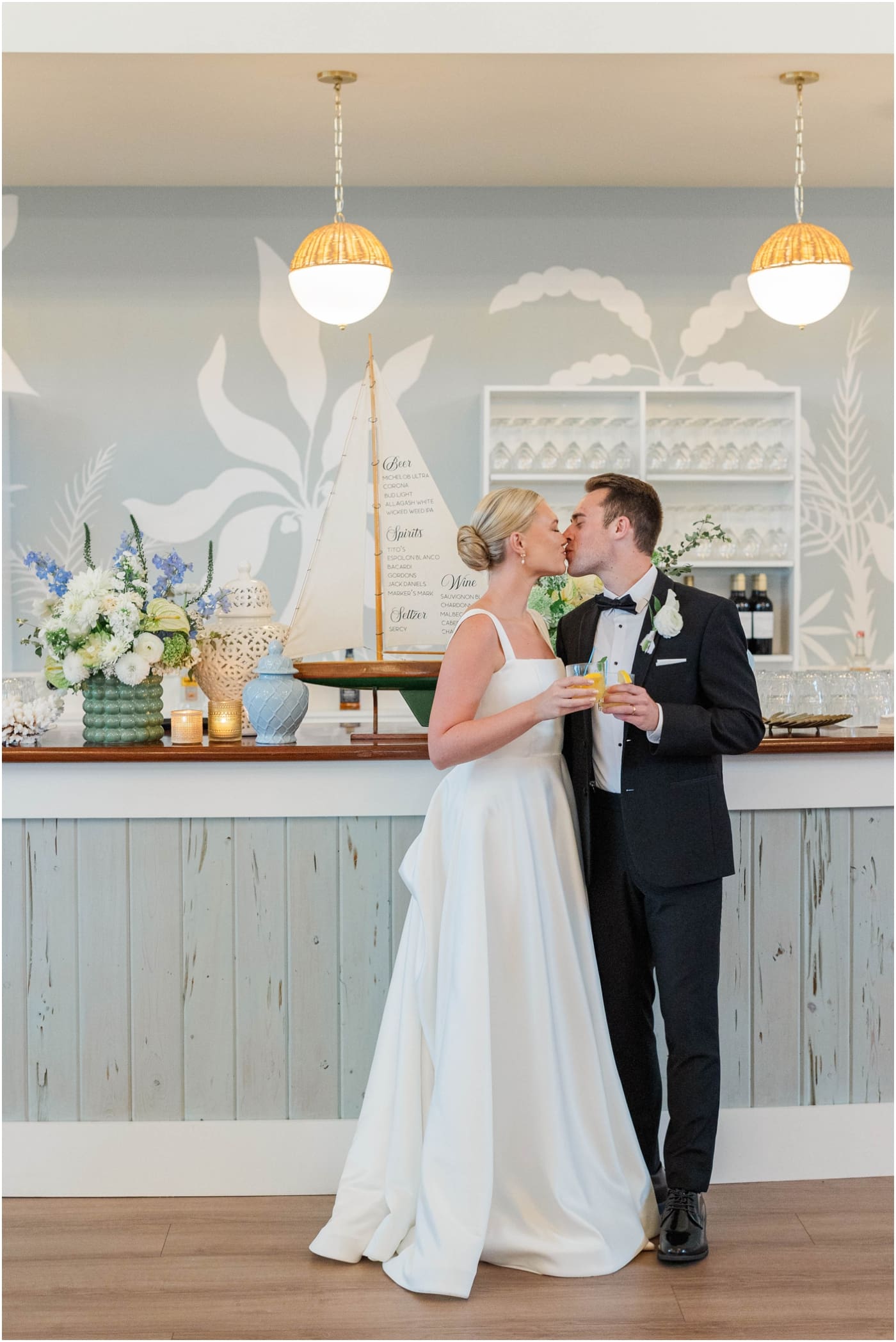 bride and groom kissing at bar at wedding reception at the coral bay club