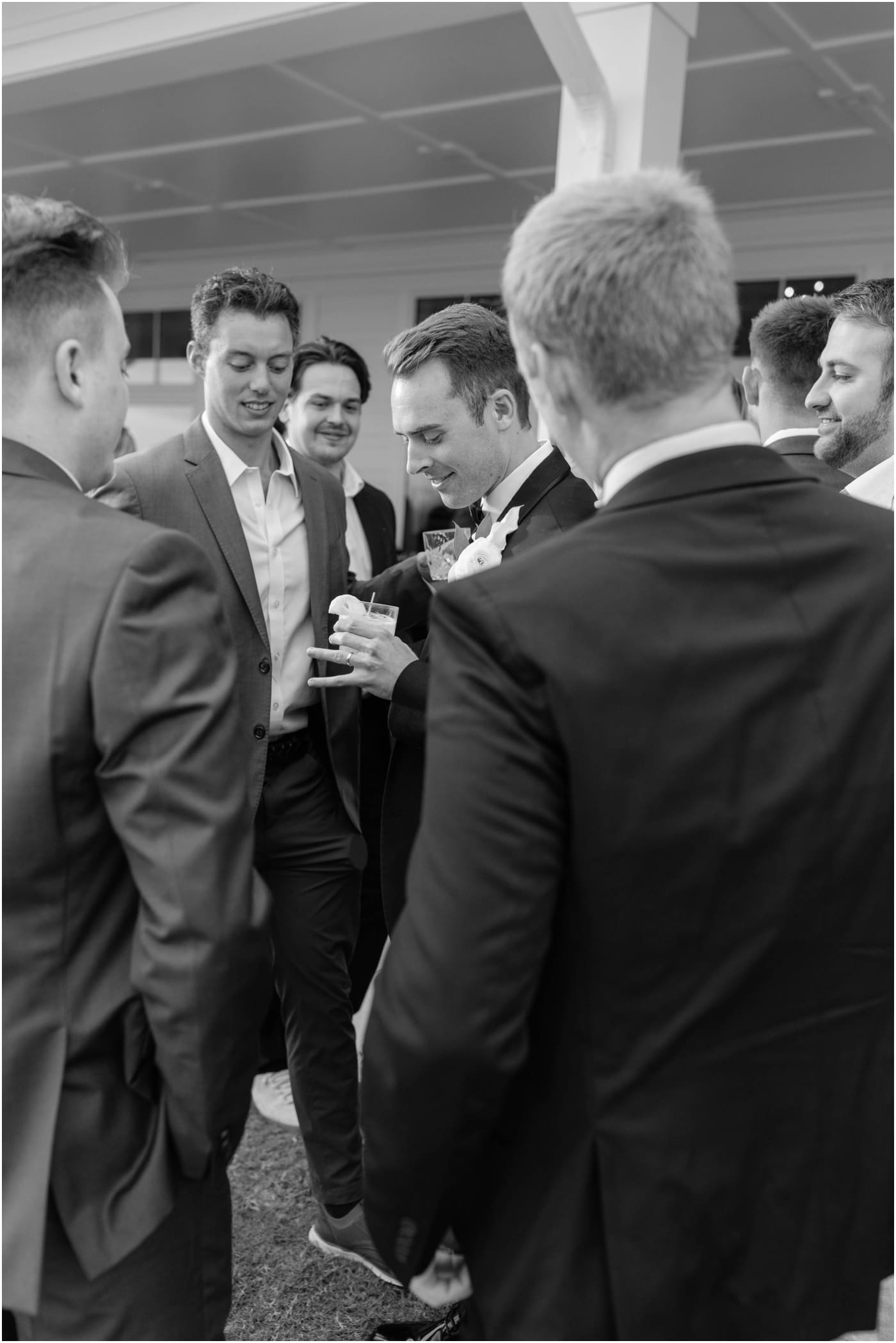 black and white photo of groom showing off ring at wedding