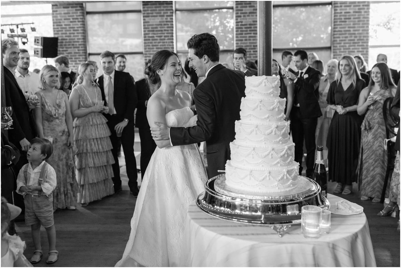 Black and white photo of couple cutting cake at their Greenville wedding at the Huguenot loft 