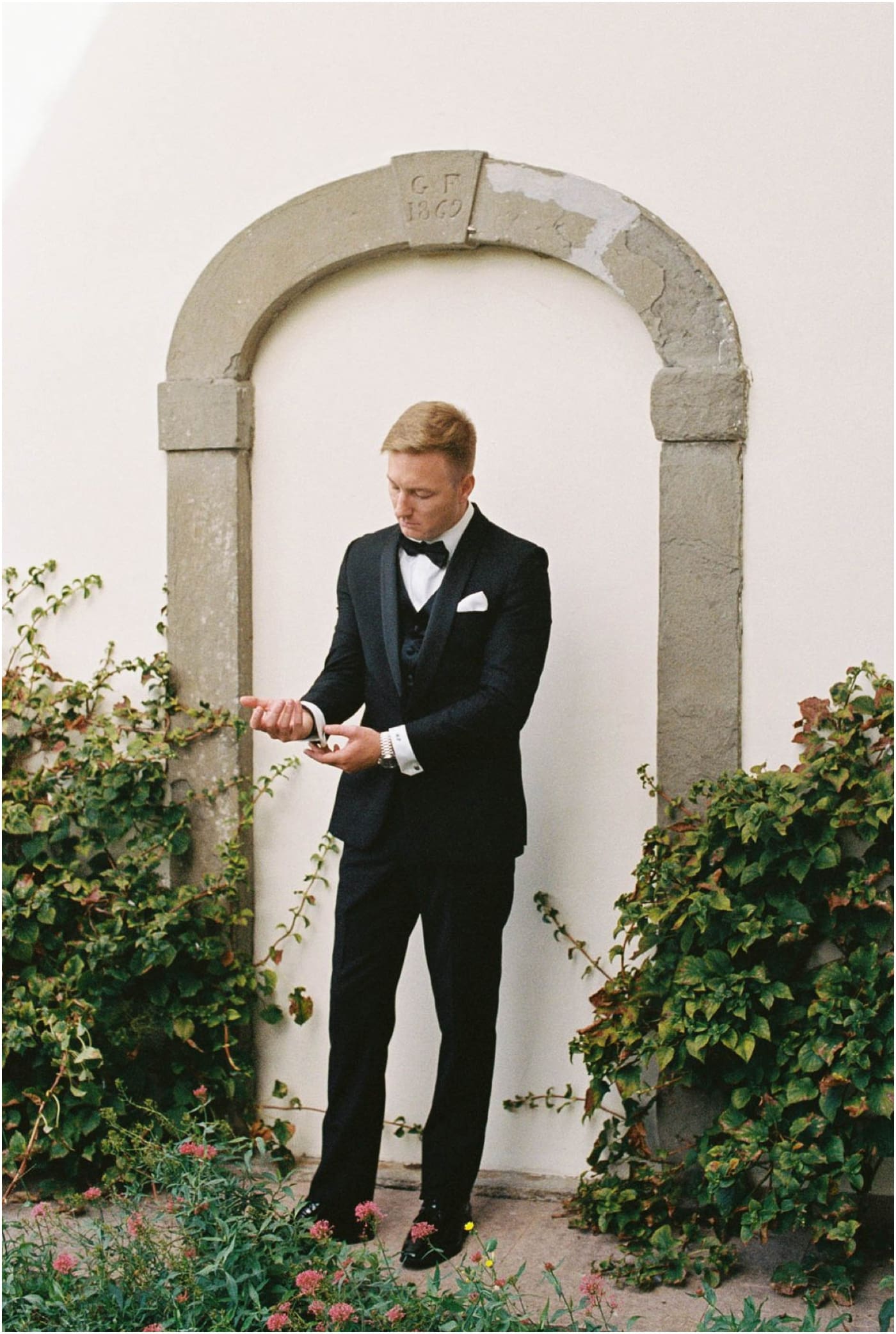 film photo of groom adjusting coat