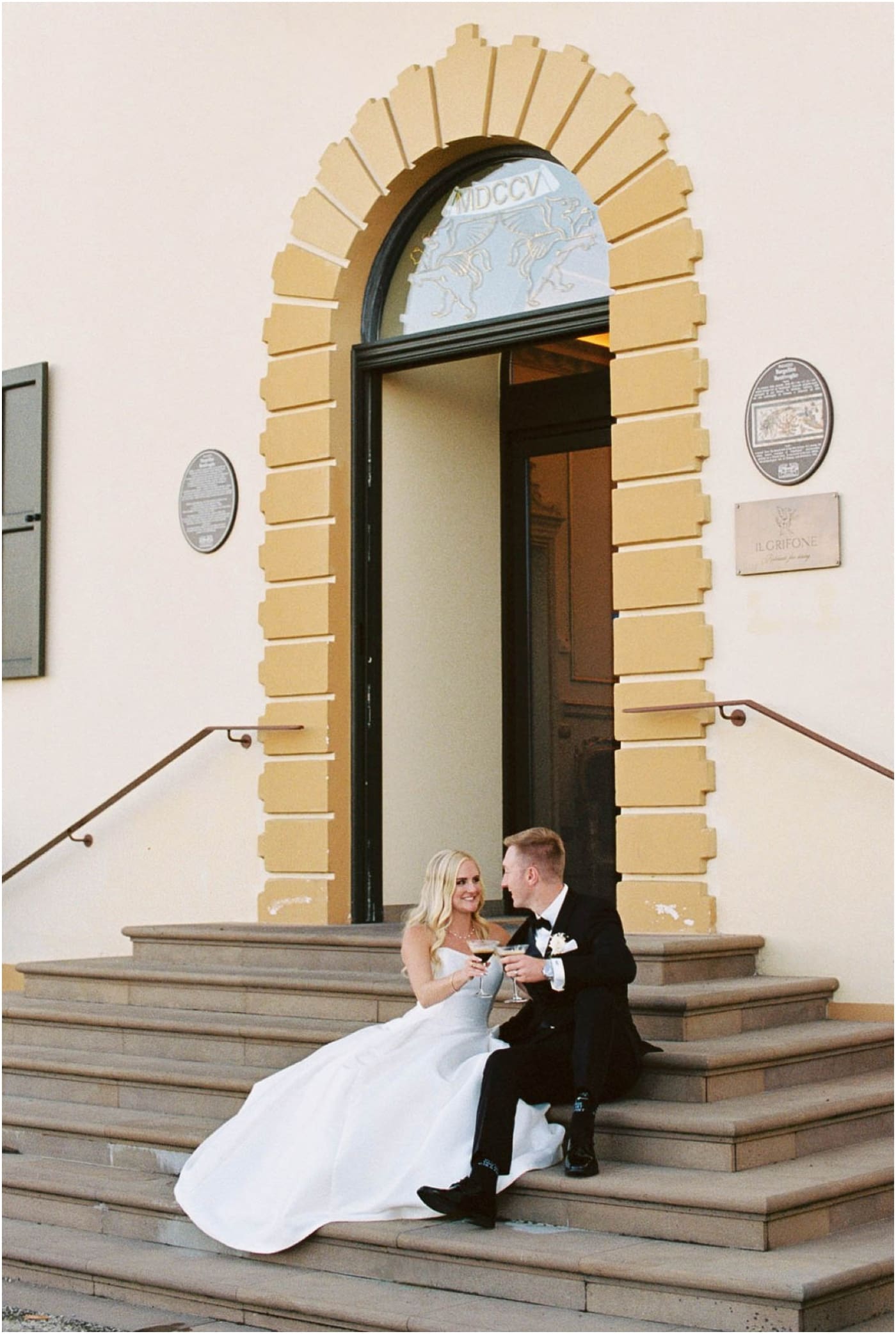 film photo of bride and groom sitting on steps of Italian wedding venue with espresso martinis 