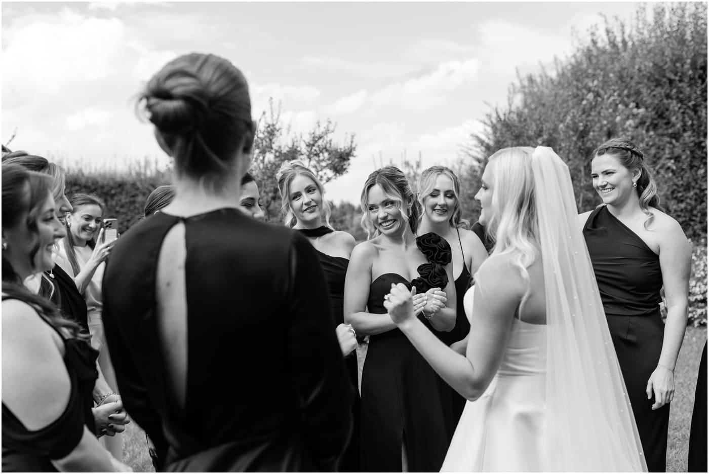 black and white photo of bridesmaids surrounding bride 