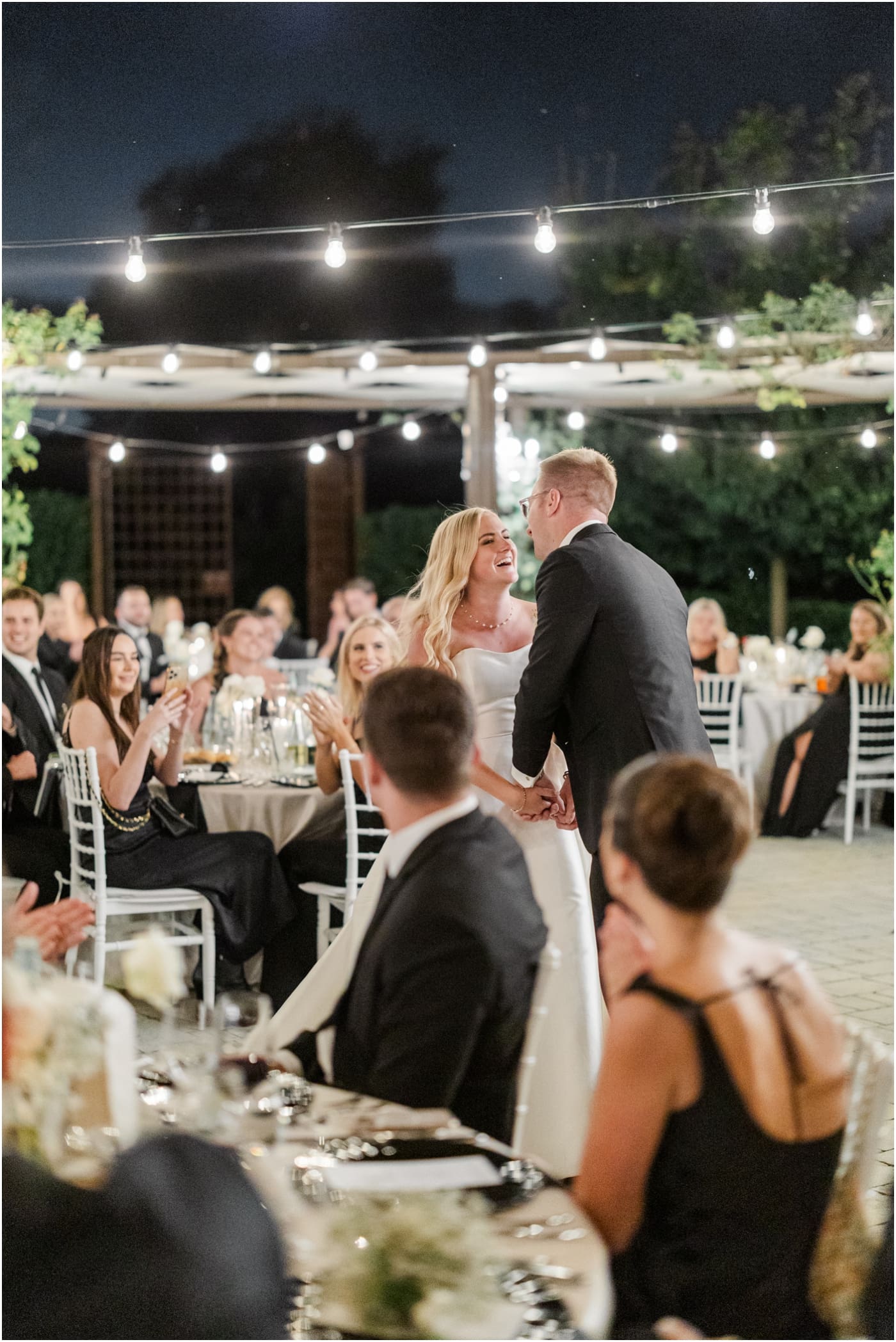 bride and groom laughing as they share first dance at outdoor reception 