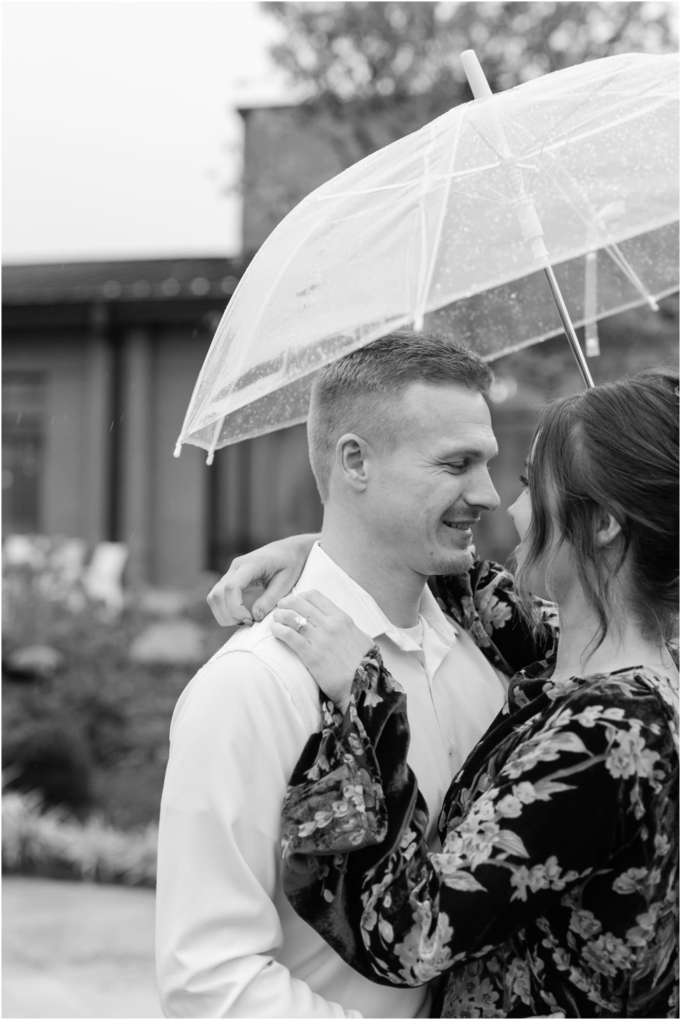 Couple under clear umbrella during a rainy hotel Hartness engagement session