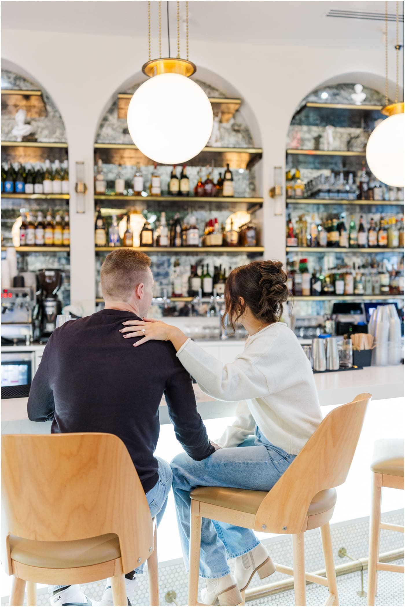 sitting in Carmellas during their coffee shop engagement session in Greenville