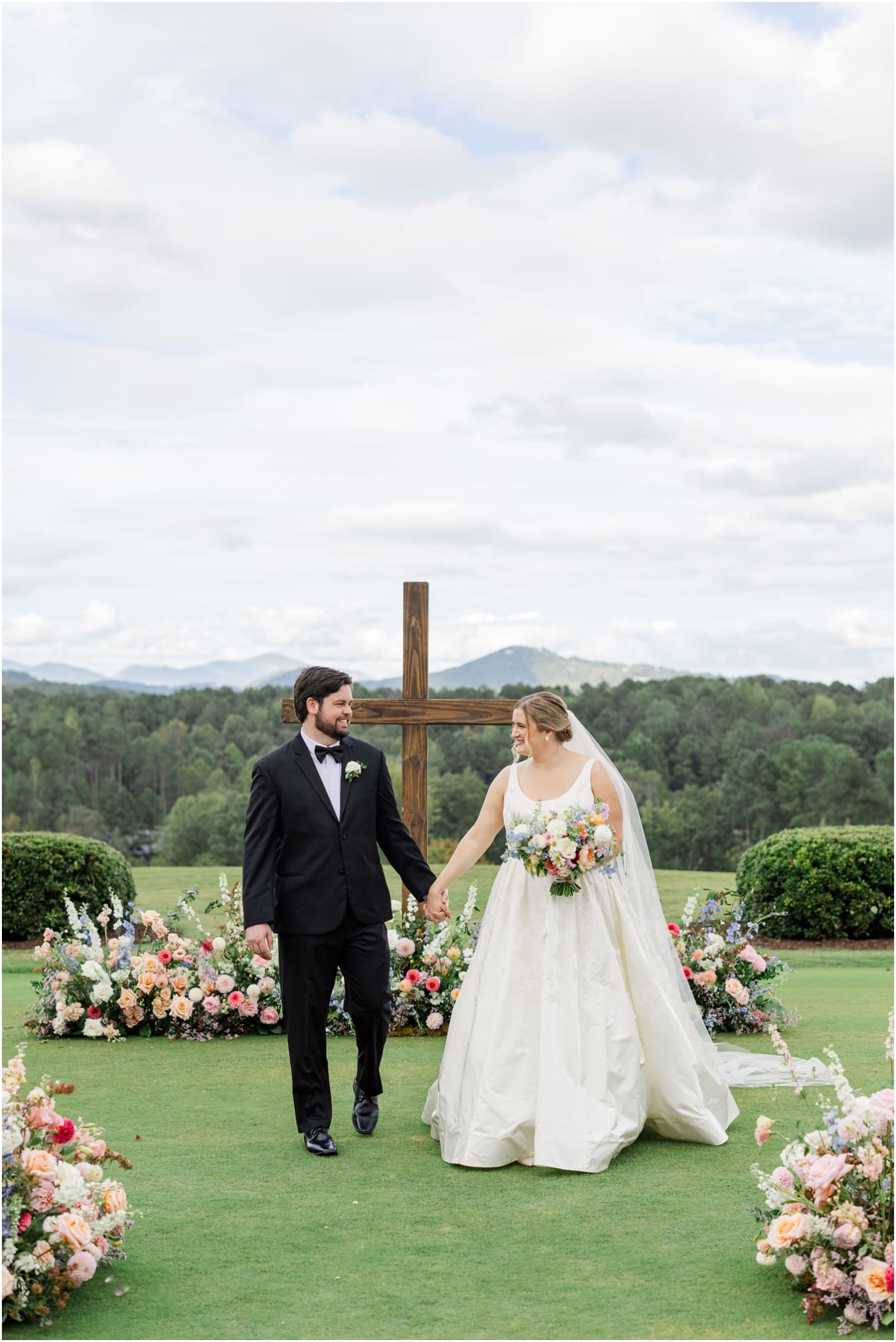 bride and groom walking down aisle with meadow florals at reserve at lake keowee wedding