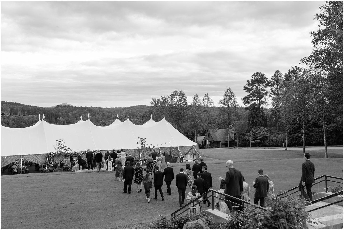 black and white of guests walking down to sailcloth tent reception at reserve at lake keowee wedding