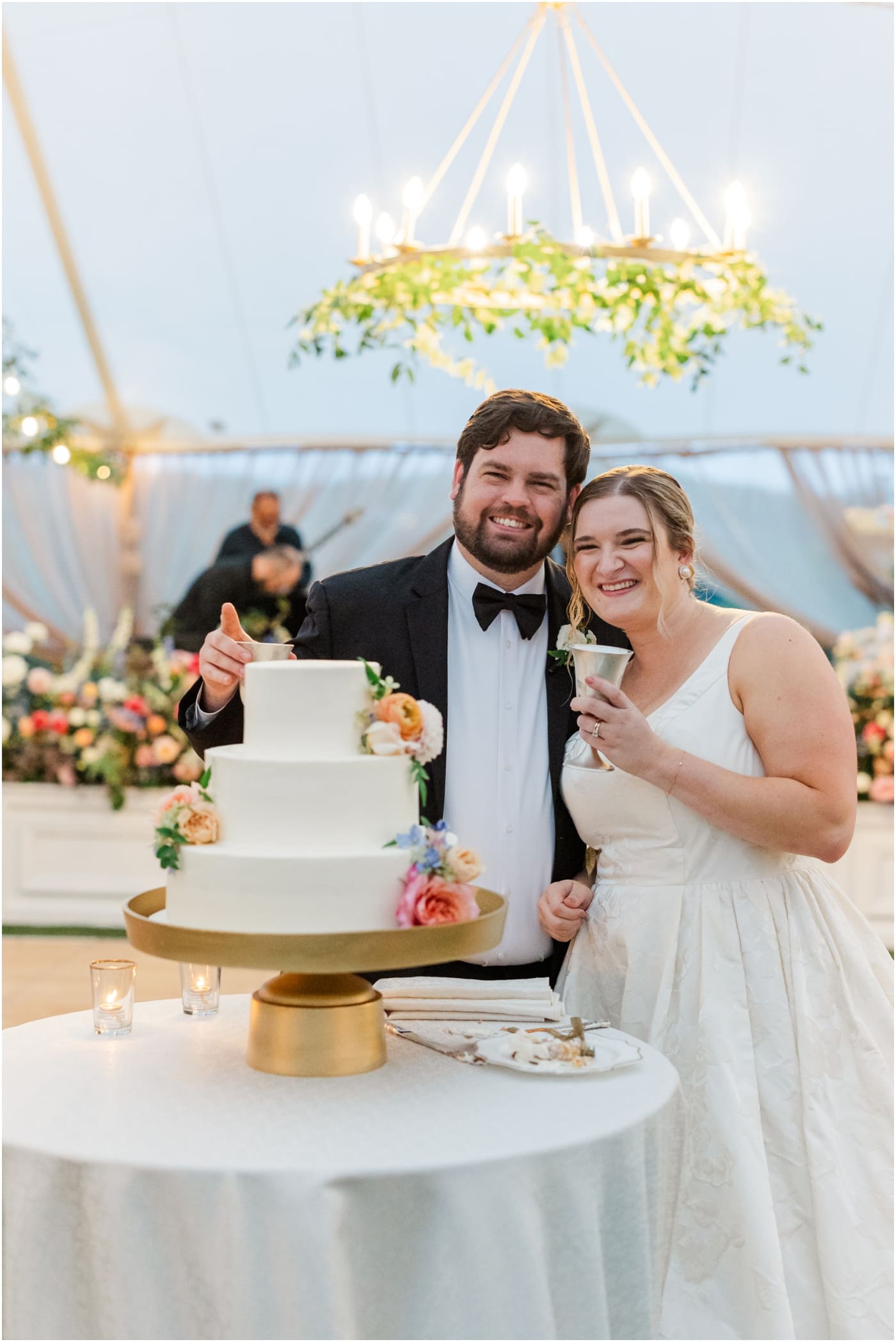 bride and groom cutting the cake at their tented reception at the Reserve at Lake Keowee Wedding
