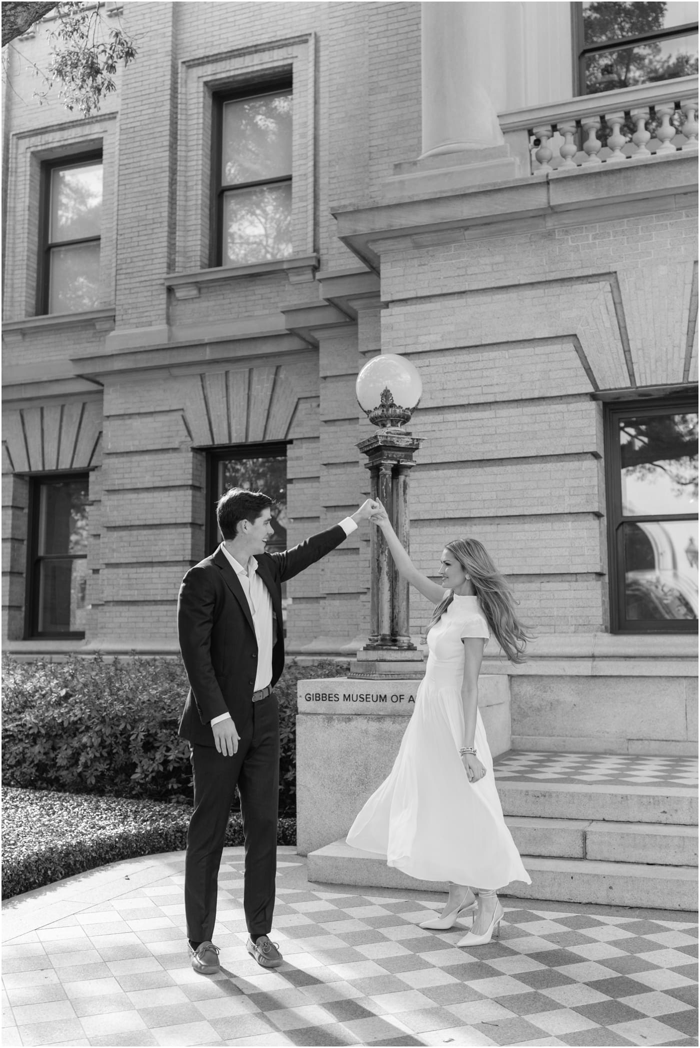 guy spinning girl on checkered floor during their engagement session at gibbes museum 