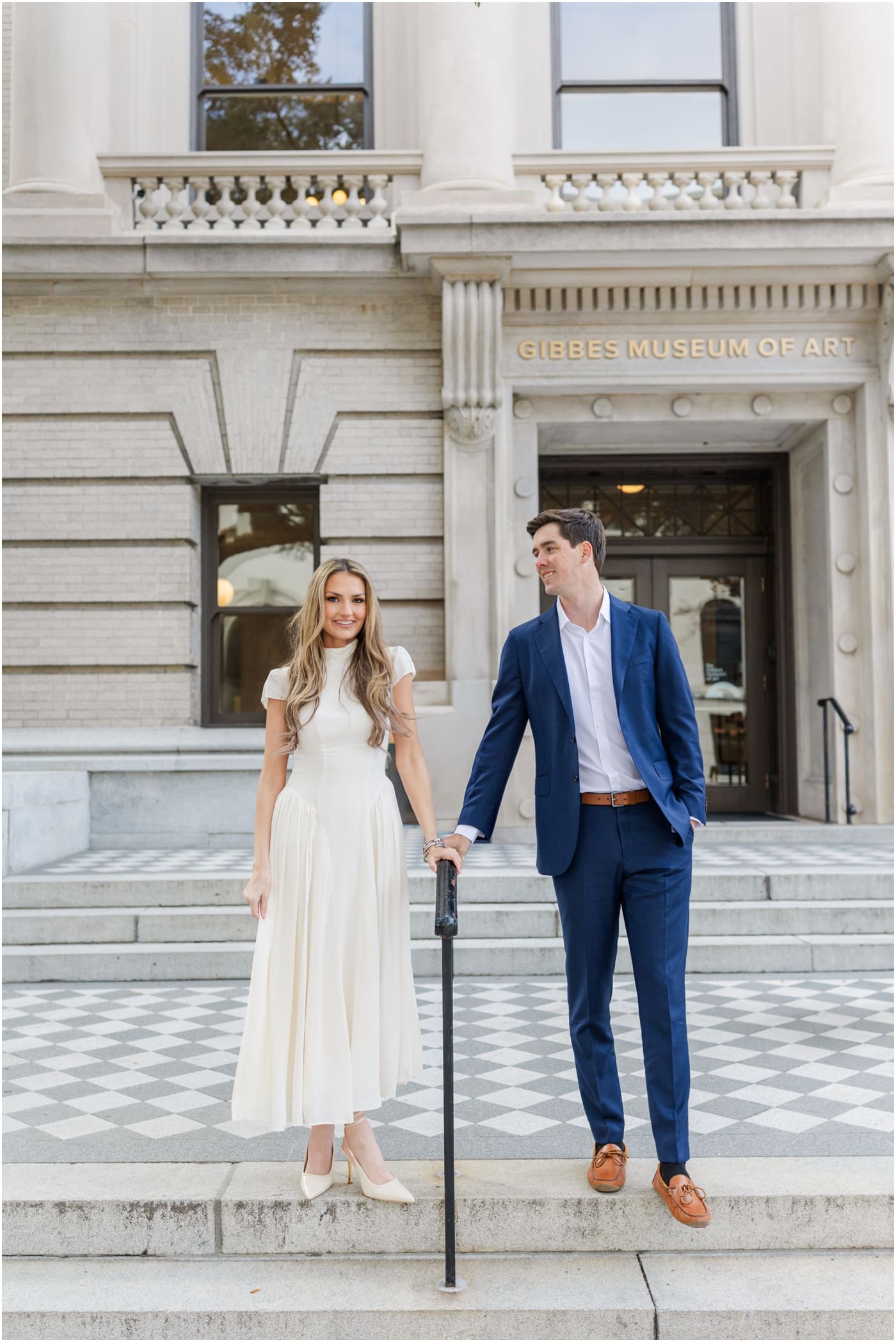 couple posing on steps on the front of the gibbes museum during their engagement session in Charleston 