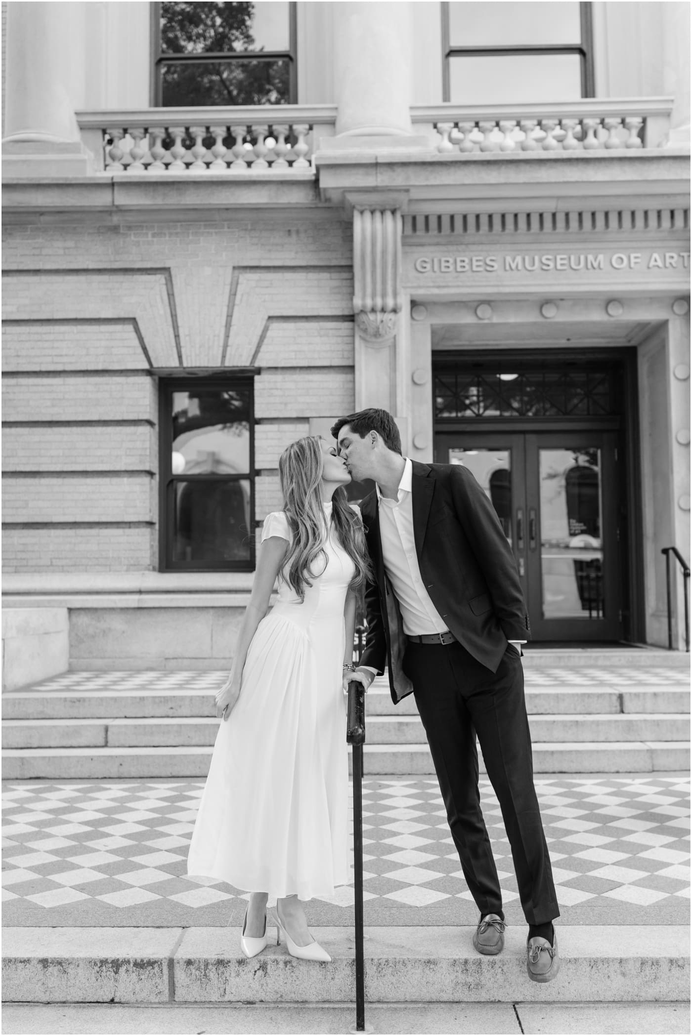 couple sharing kiss on steps out front of gibbes museum during their Charleston engagement session